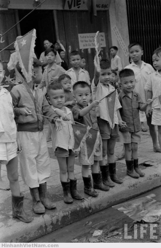 Trẻ em trên phố Hàng Bạc cầm cờ vẫy chào bộ đội Việt Minh